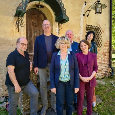 Kreistagsfraktion 2020 bis 2026 der Grünen im Passauer Land. Sechs Personen stehen vor einem Haus und lächeln in die Kamera.