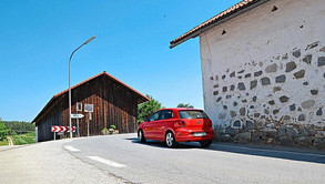Die 90-Grad-Kurve in Rohrbach ist ein Hauptargument für die Umfahrung, die das Dorf komplett umgehen würde. Bei Schuberls Alternative könnte das rote Auto geradeaus weiterfahren. − Foto: Kain 