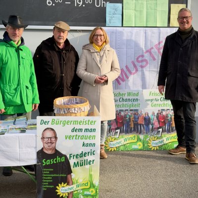 Vier Personen stehen hinter einem Infostand. Sie informieren zur Kommunalwahl 2026 in Bayern.